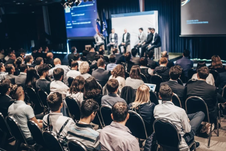 Gente sentada asistiendo a un evento organizado mediante La norma ISO 20121 es una herramienta clave para hacer más sostenible la manera en que planificamos y ejecutamos cualquier la ISO 20121