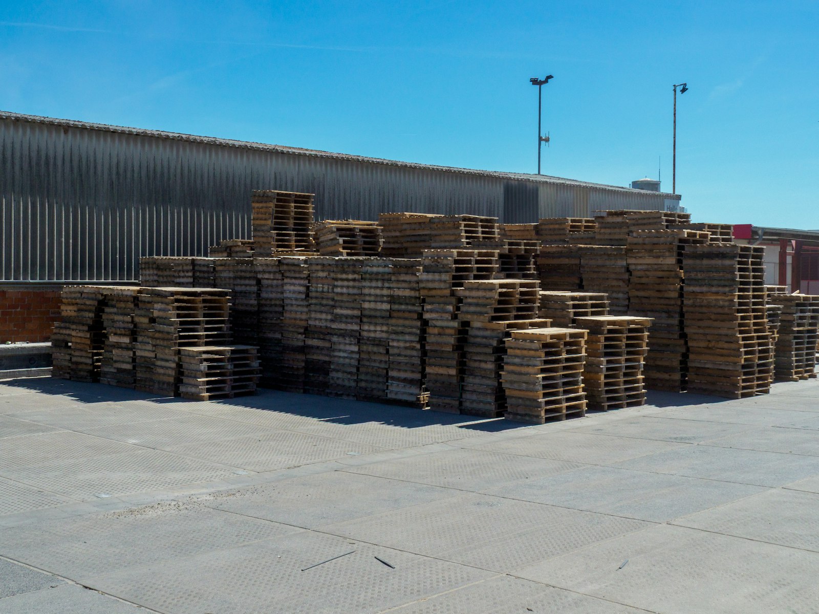 Palés de madera apilados junto a un almacén