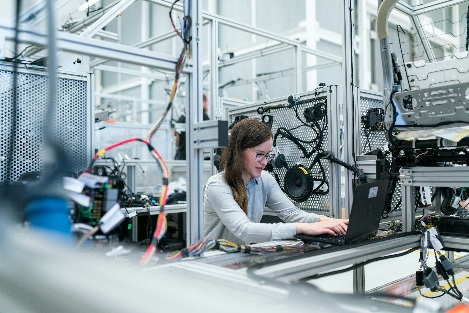 Técnica revisando datos con un portátil en una instalación industrial
